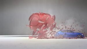A BMW M5 shattering a big red glass apple at high speed.